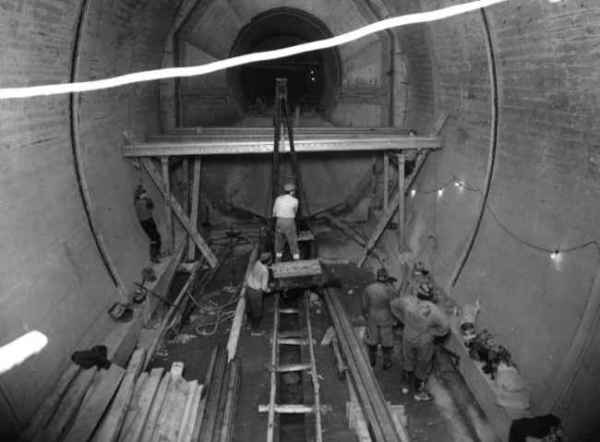 Tunnel No 8 Portal frames for main floor being erected by means of compressed air winch and jib mounted on a Eimco locomotive - 13 March 1956